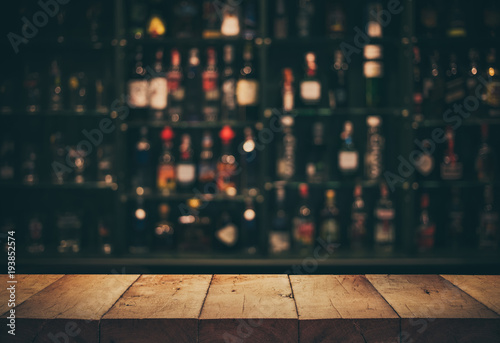 Fotobehang Empty the top of wooden table with blurred counter bar and bottles Background