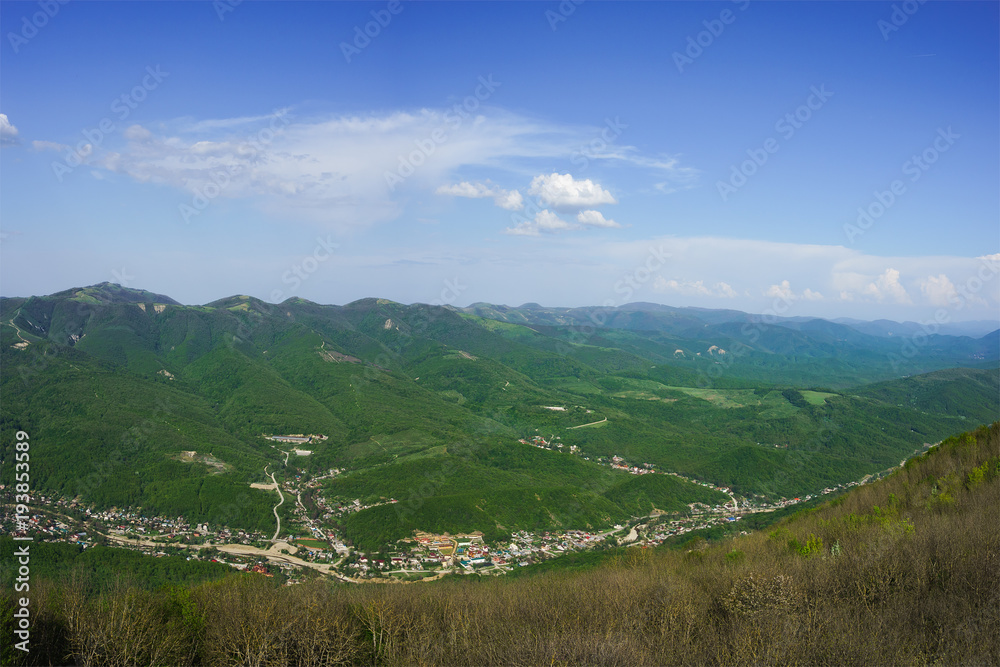 The view from the Markotkh mountain range to the valley of the river Derby village Derbienko and beautiful main Caucasian ridge