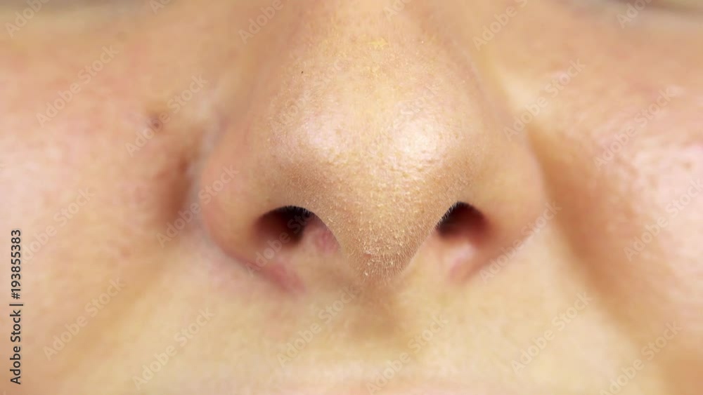 A woman smells with her nose - closeup A woman smells with her nose - closeup