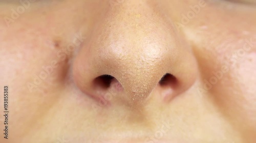 A woman smells with her nose - closeup