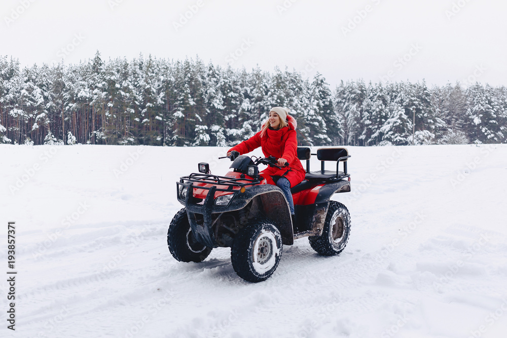 A pretty girl riding a quadrocycle in a picturesque snowy area A pretty girl riding a quadrocycle in a picturesque snowy area