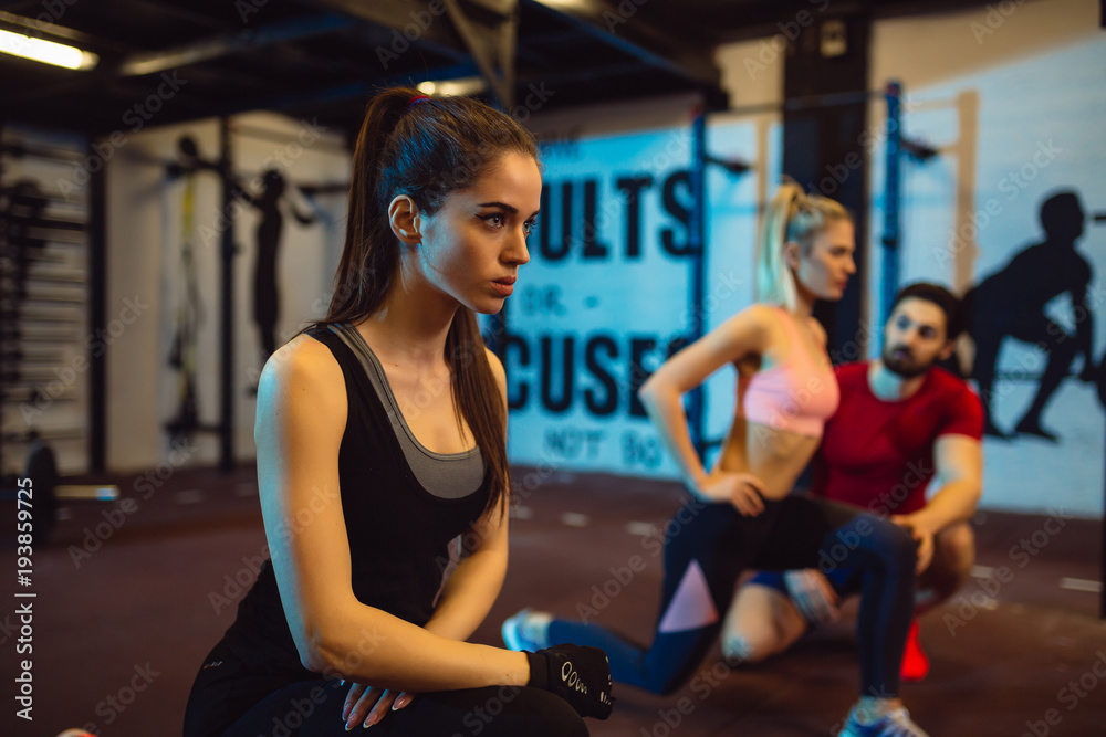 Close up of motivated focused attractive young fitness woman doing squad.