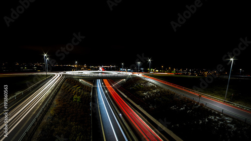 light trails for cars passing a roundabout and roadside sides
