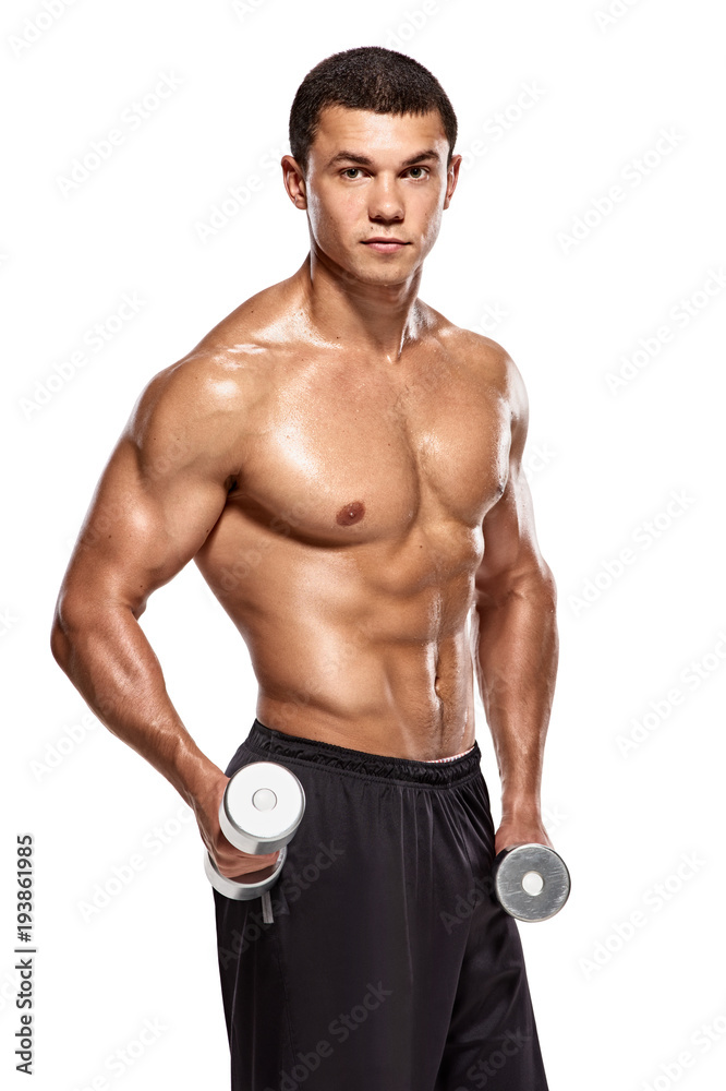 Young bodybuilder with dumbbells. Handsome smiling strong athletic man training with dumbbells Young bodybuilder with dumbbells. Handsome smiling strong athletic man training with dumbbells