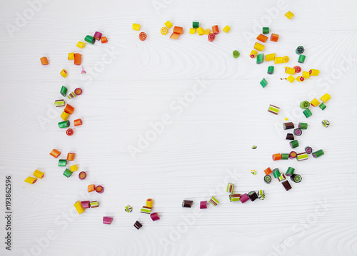 Colorful lollipops, candy canes and sweet candies mix on wooden background