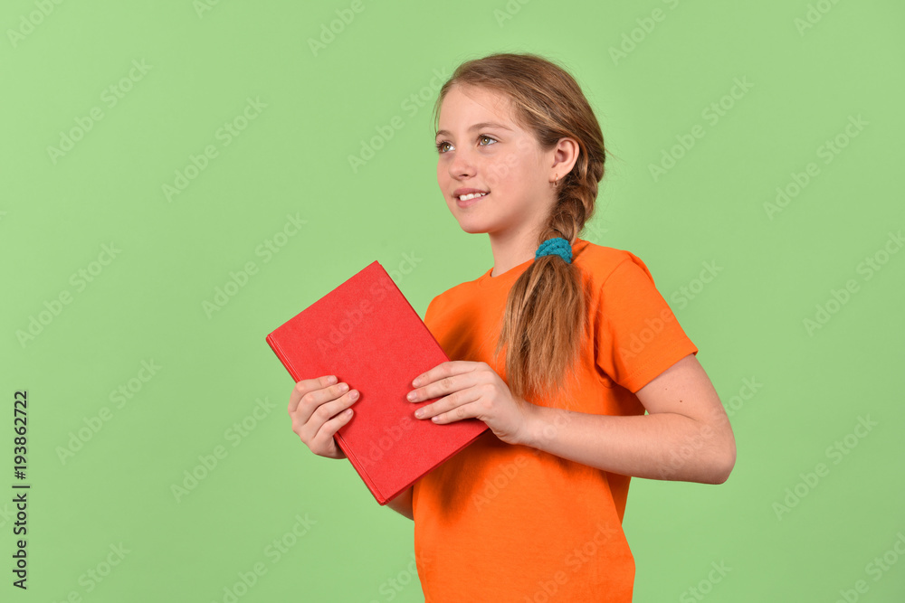 A schoolgirl with books. Happy childhood. A girl in an orange T-shirt. A schoolgirl with books. Happy childhood. A girl in an orange T-shirt.