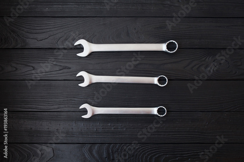 Spanners or adjustable wrenches on black wooden background, Basic hand tools. With copy space.