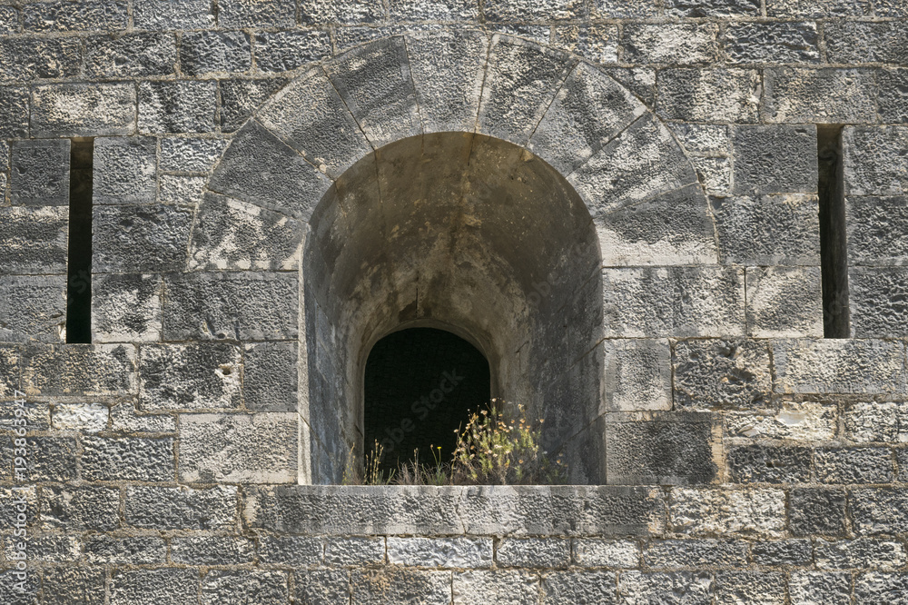 Detail of medieval fortress wall with loopholes at Corfu, Greece. 
