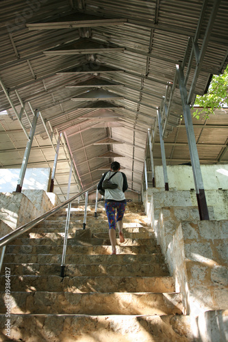 Climbing the many steep staircases to the summit of the hill of the Su Taung Pyae Pagoda over Mandalay in Myanmar photo