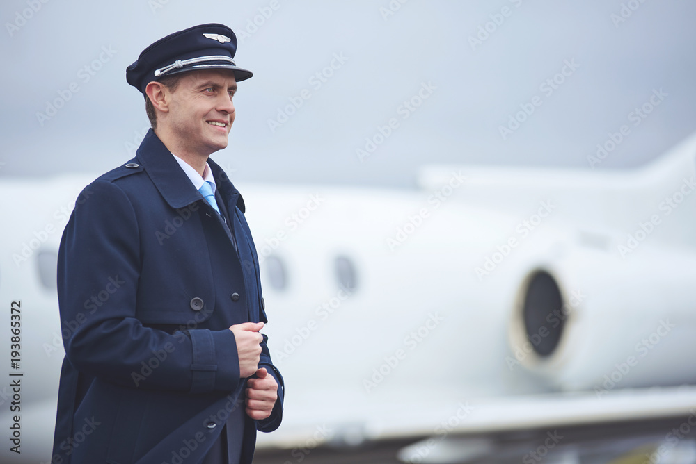 Side view smiling aviator moving outdoor opposite plane. Job concept. Copy space Side view smiling aviator moving outdoor opposite plane. Job concept. Copy space