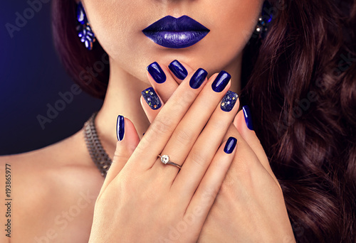 Beautiful woman with perfect make-up and blue manicure wearing jewellery