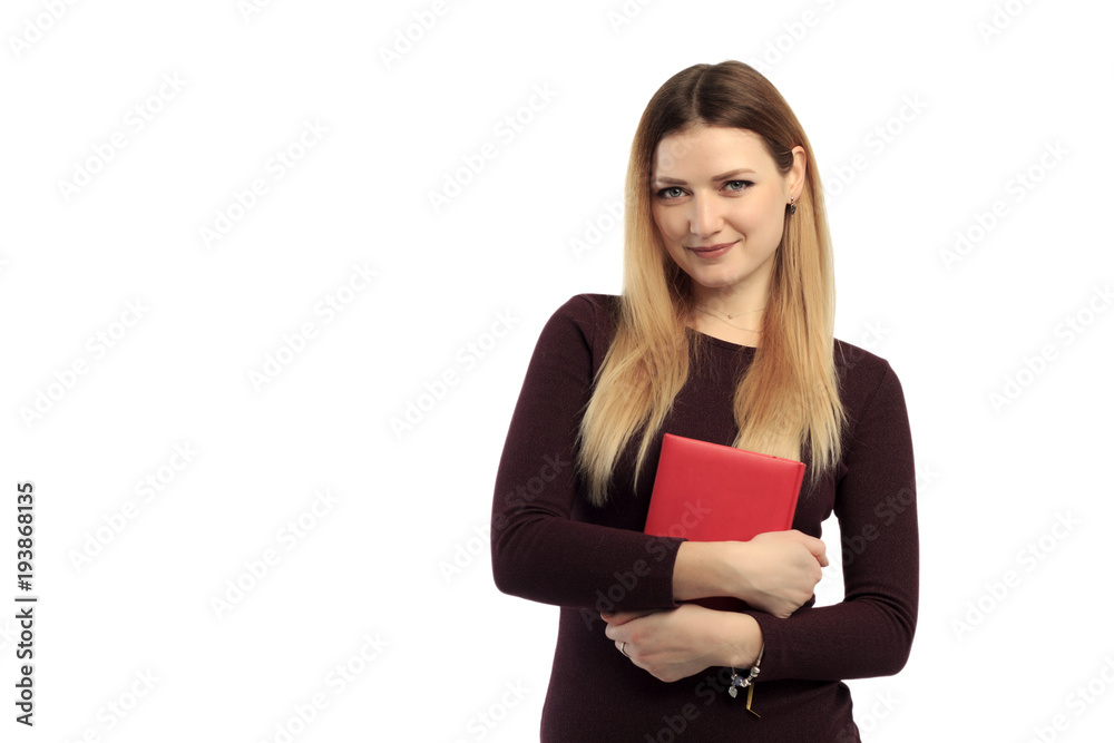 Young charming girl in sweater holding book and tablet and smiling at camera. Young charming girl in sweater holding book and tablet and smiling at camera.