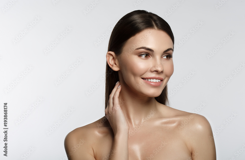 Portrait of happy young woman touching her skin with satisfaction. She is standing with naked shoulders and smiling. Isolated and copy space Portrait of happy young woman touching her skin with satisfaction. She is standing with naked shoulders and smiling. Isolated and copy space