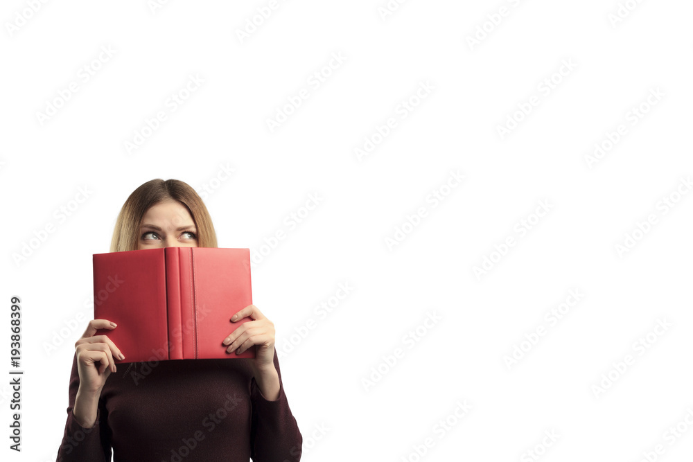 Portrait of a pretty casual girl holding open book at her face isolated over white background Portrait of a pretty casual girl holding open book at her face isolated over white background