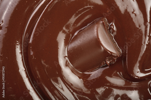 Melted chocolate and pieces of chocolate bar as a background closeup