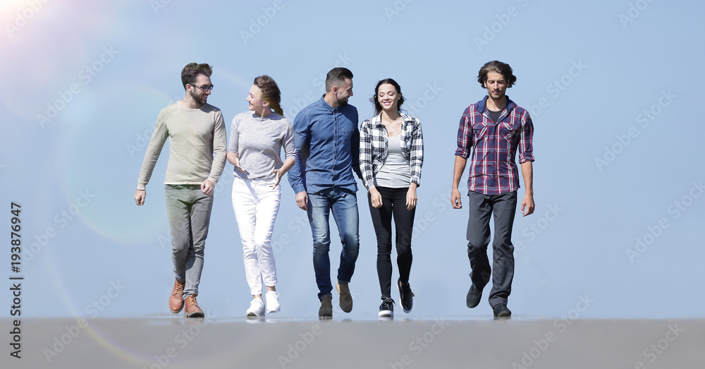 Obraz premium team of young people walking along the road.outdoors