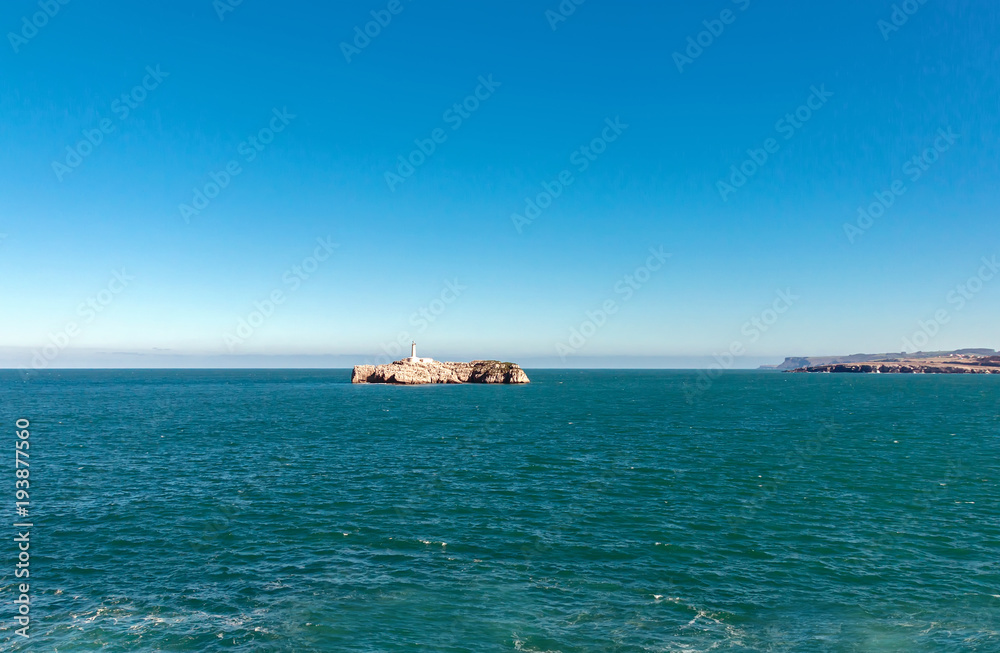 Rock island surrounded by calm blue sea landscape