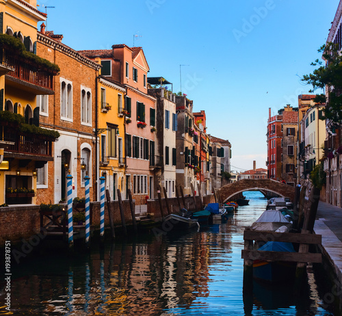 Beautiful Venice sunset cityscape, narrow water canal, bridge and traditional buildings. Italy, Europe.
