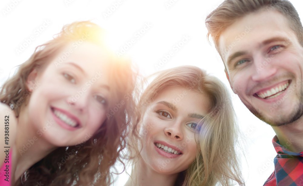 closeup of three young people smiling on white background closeup of three young people smiling on white background