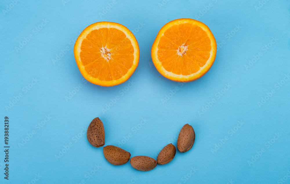 Fototapeta premium Healthy smiling face with oranges and almonds