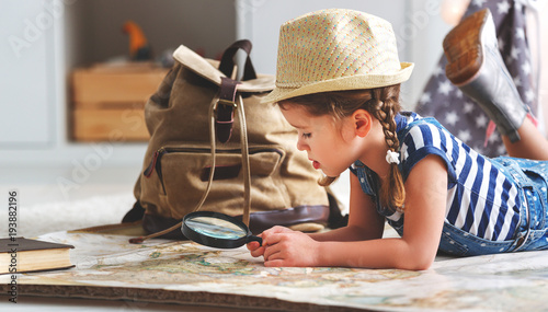 funny child girl tourist with world map, backpack and magnifier.