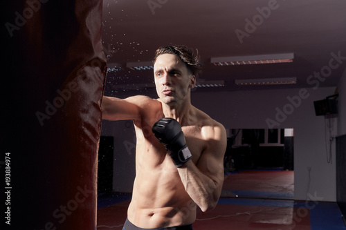 one agressive boxer, upper body shot. boxing gloves, punching boxing bag. © HD92