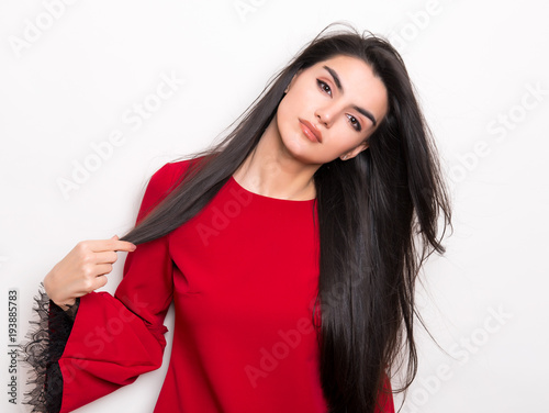 beautiful young woman with long black hair posing in red dress