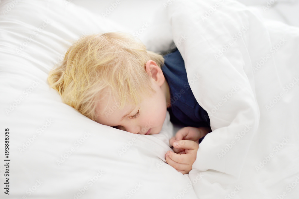 Cute little boy sleeping. Tired child taking a nap in parent's bed. Cute little boy sleeping. Tired child taking a nap in parent's bed.