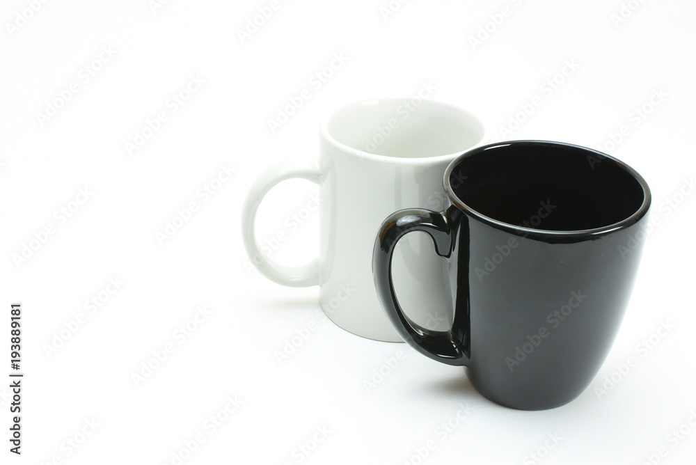 black coffee mug in front of white coffee mug, high key