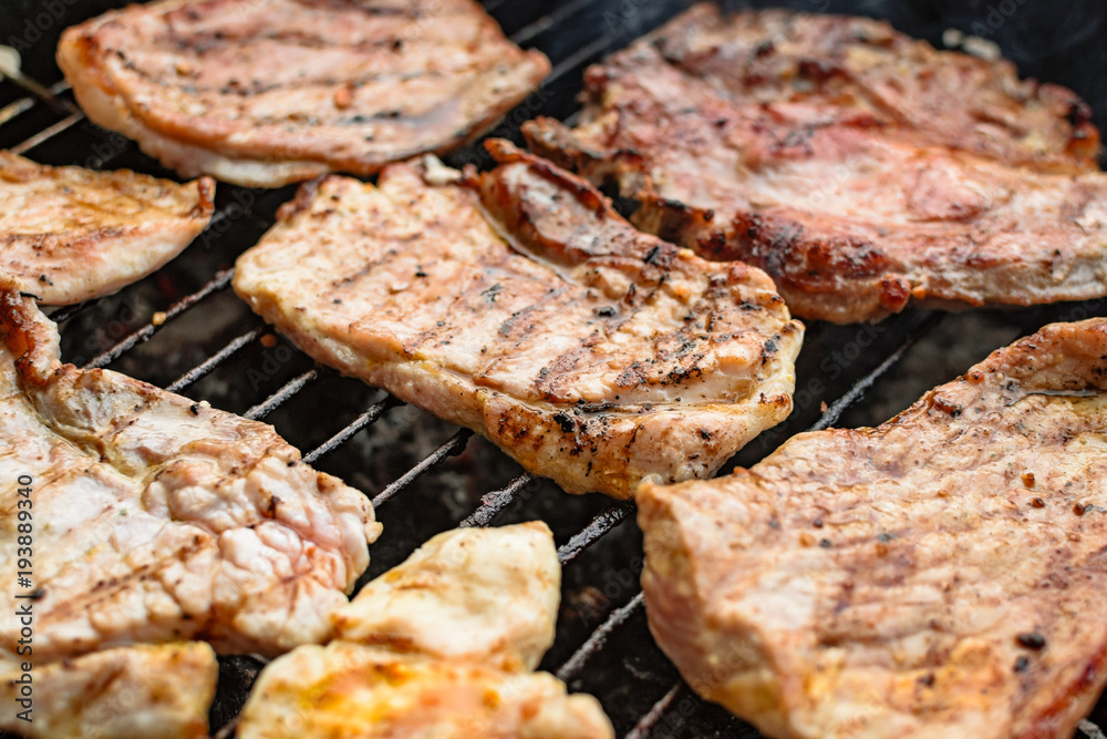Grilled meat, pork, beef and chicken meat on barbecue, grill. Shallow depth of field.