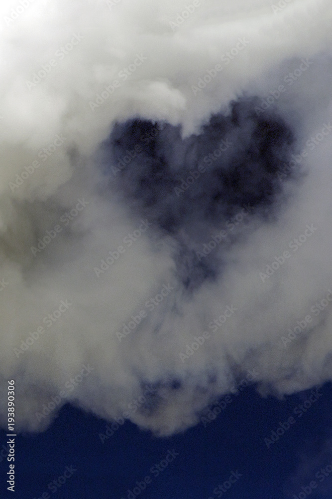 Heart in a white cloud on a dark blue sky. Background for design. Vertical picture. Heart in a white cloud on a dark blue sky. Background for design. Vertical picture.