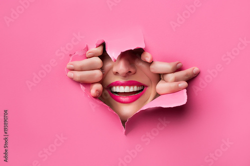 Obraz na plátně close-up of female fingers, nose and lips with pink lipstick and a broad smile t