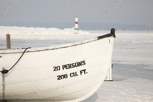 Wooden boat, Petoskey Pierhead Lighthouse, Petoskey, Michigan in winter photo