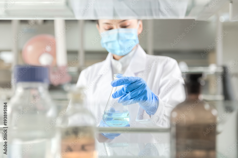 Fototapeta premium Female scientist looking at the scientific sample in the laboratory
