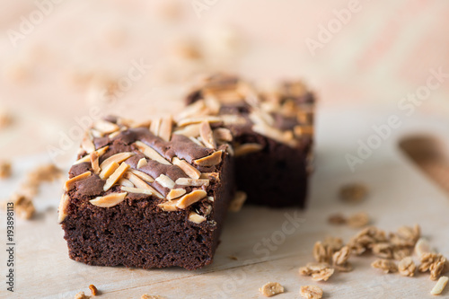 Close up sweet chocolate brownie with almond topping, selective focus