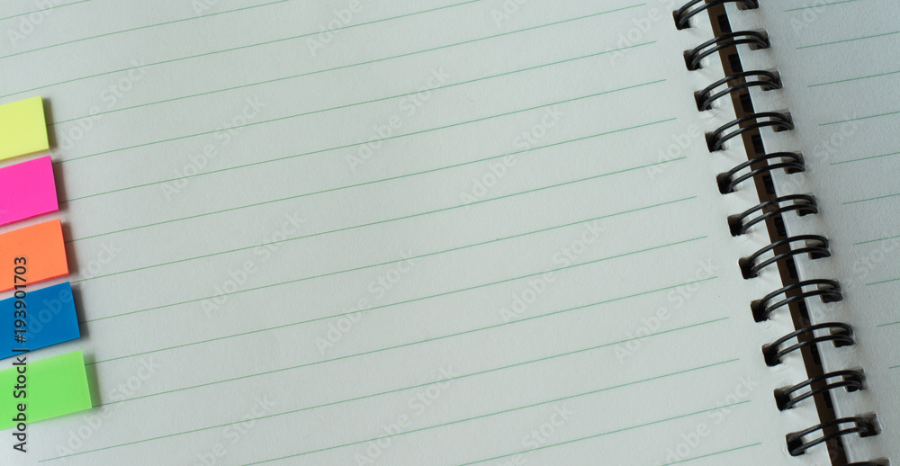White paper with blank space and color post it on notebook White paper with blank space and color post it on notebook