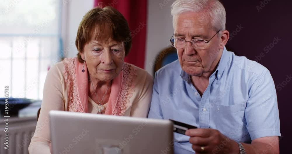 4k, A senior couple using a laptop at home. 4k, A senior couple using a laptop at home.