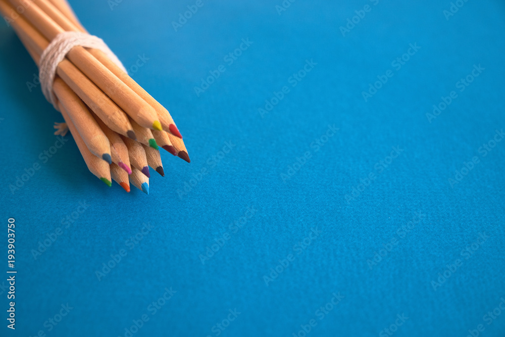 Set of colored pencils against blue background - obrazy, fototapety, plakaty 