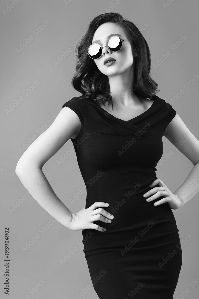 Fototapeta premium Young beautiful woman in black dress and sunglasses