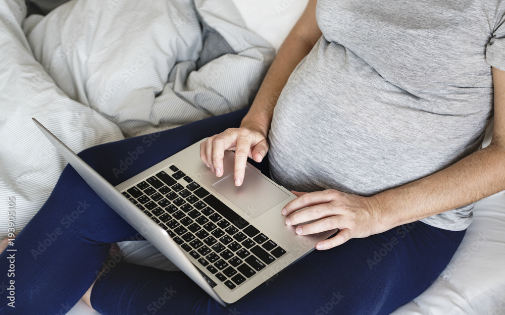 Naklejka premium Pregnant woman using computer laptop