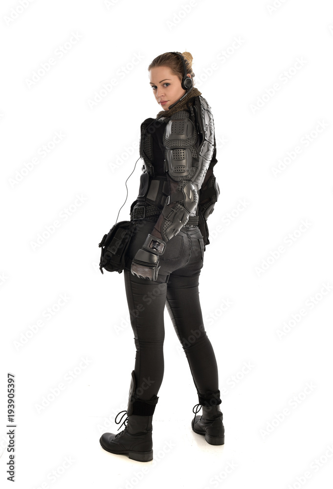 full length portrait of female soldier wearing black tactical armour facing away from camera, isolated on white studio background. full length portrait of female soldier wearing black tactical armour facing away from camera, isolated on white studio background.
