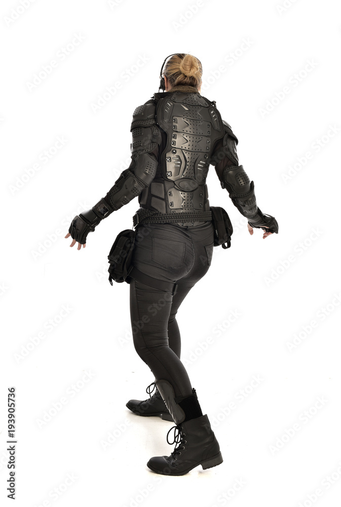 full length portrait of female  soldier wearing black  tactical armour  facing away from camera, isolated on white studio background.