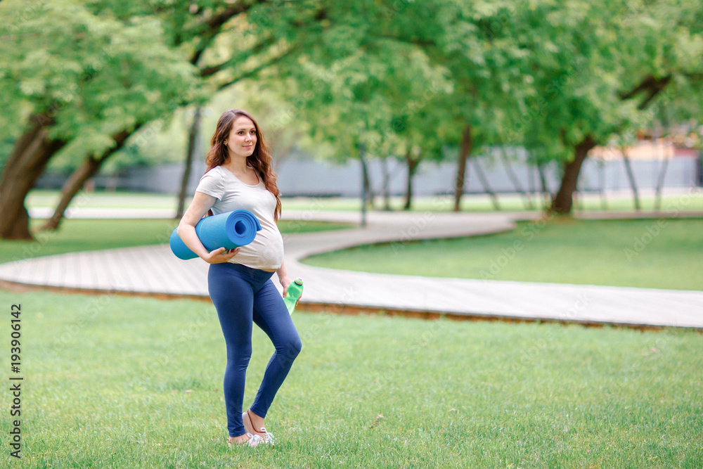 Pregnant girl with a gymnastic Mat and bottle of water. Pregnant girl with a gymnastic Mat and bottle of water.