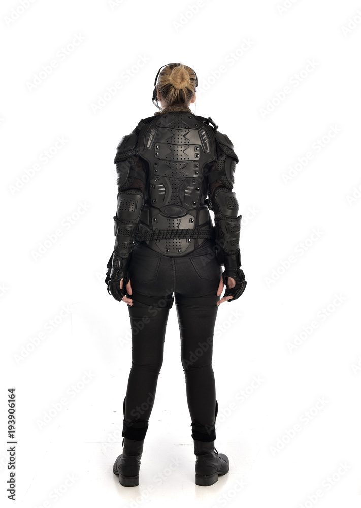full length portrait of female soldier wearing black tactical armour facing away from camera, isolated on white studio background. full length portrait of female soldier wearing black tactical armour facing away from camera, isolated on white studio background.