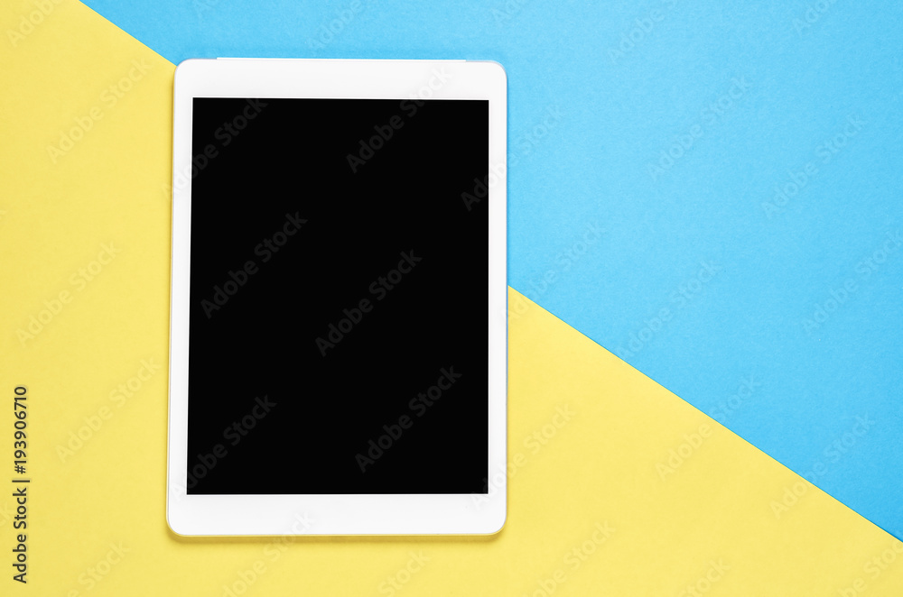 Top view, Modern workplace with tablet placed on a pastel yellow background. Copy space suitable for use in graphics. Top view, Modern workplace with tablet placed on a pastel yellow background. Copy space suitable for use in graphics.