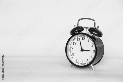 Black and white picture of Old Alarm Clock analog classic vintage style on paper retro background and copy space.