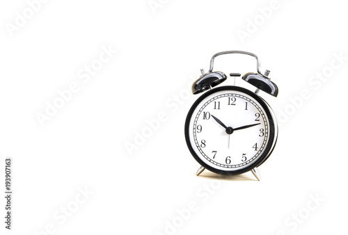 White light over Image of Black Alarm Clock classic vintage style. Isolated on white background and copy space.