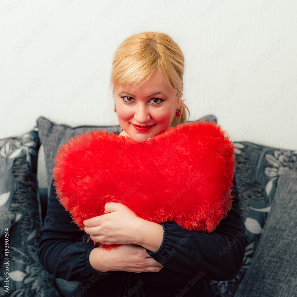 Blonde woman with red pillow heart shaped. Saint Valentine and International Women's Day, Eight 8 March celebration. Blonde woman with red pillow heart shaped. Saint Valentine and International Women's Day, Eight 8 March celebration.