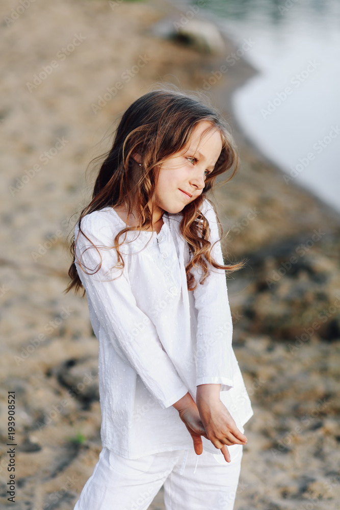 Portrait of a cute little girl on a beach background. Concept of a happy childhood Portrait of a cute little girl on a beach background. Concept of a happy childhood