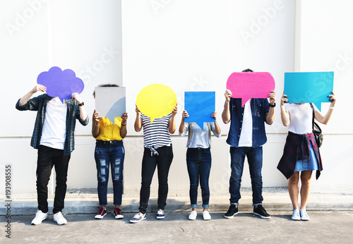 Young adult friends holding up copyspace placard thought bubbles photo